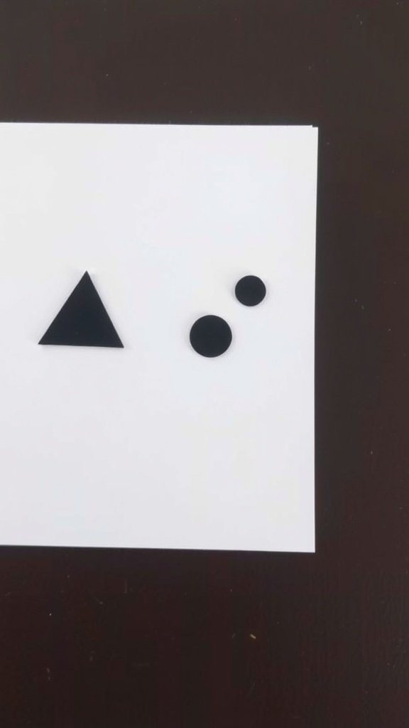 A geometric minimalist card featuring a black triangle and two black circles on a white background